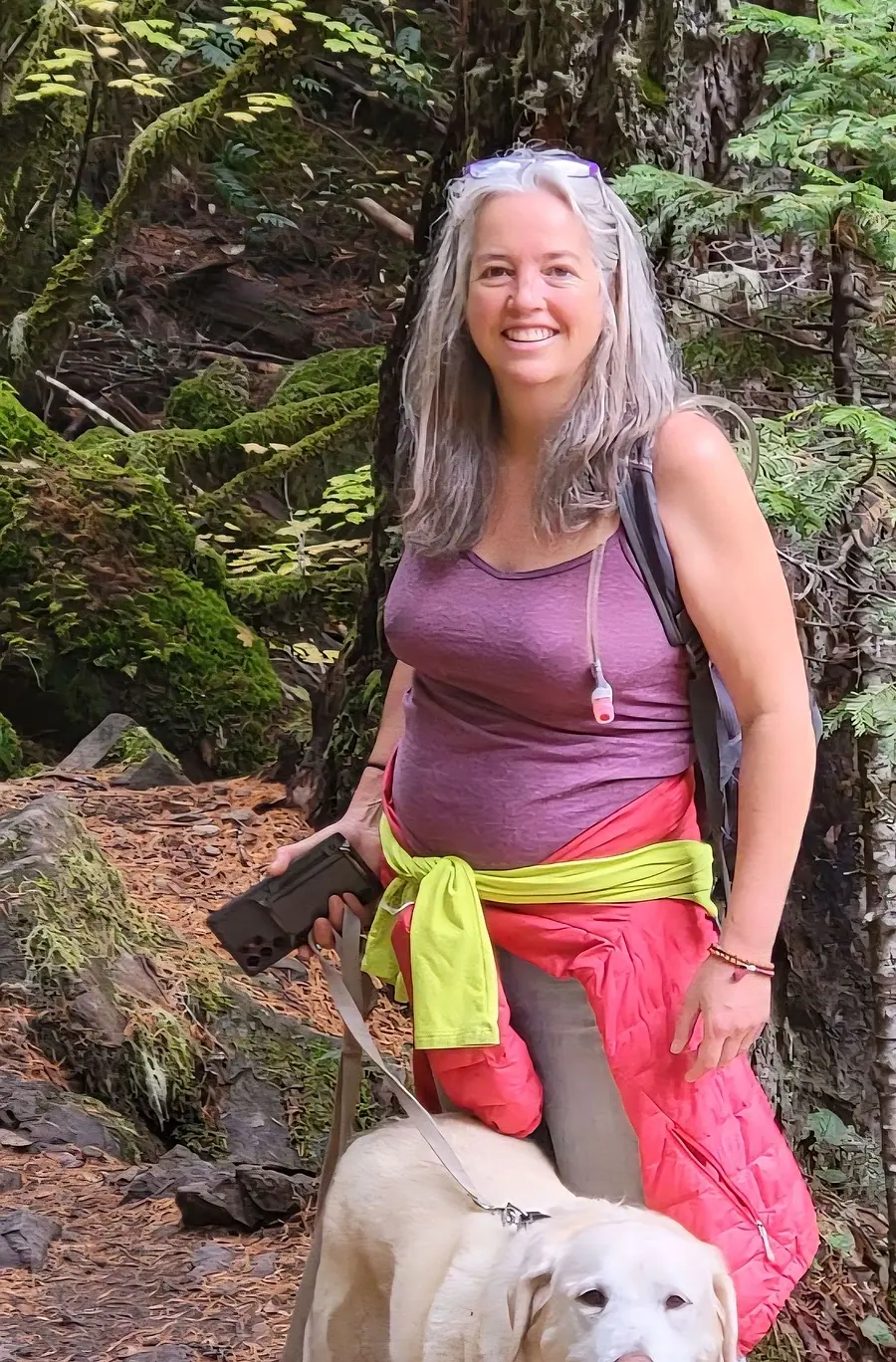 Bernice on a mossy forest trail with her white dog